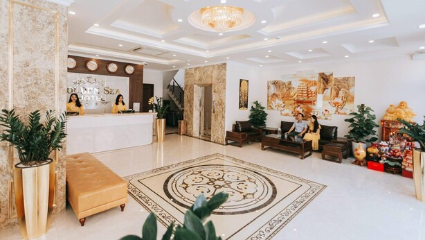 A spacious lobby with a reception desk, seating area, and decorative elements like plants and artwork. - Golden Sea Hotel (Bai Chay)