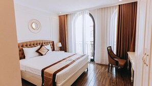 A hotel room with a large bed, a desk, and a chair. - Golden Sea Hotel (Bai Chay)
