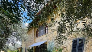 A stone house with a garden, a blue awning, and a gate. - VILLA GIOTTO, FLORENCE (Impruneta)