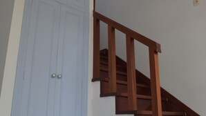 Una escalera con escalones de madera y una pared blanca.