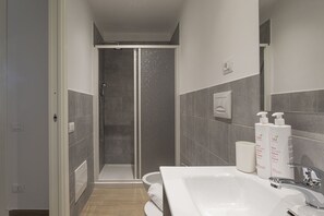 Eenvoudig appartement | Badkamer | Een douche, gratis toiletartikelen, handdoeken, zeep