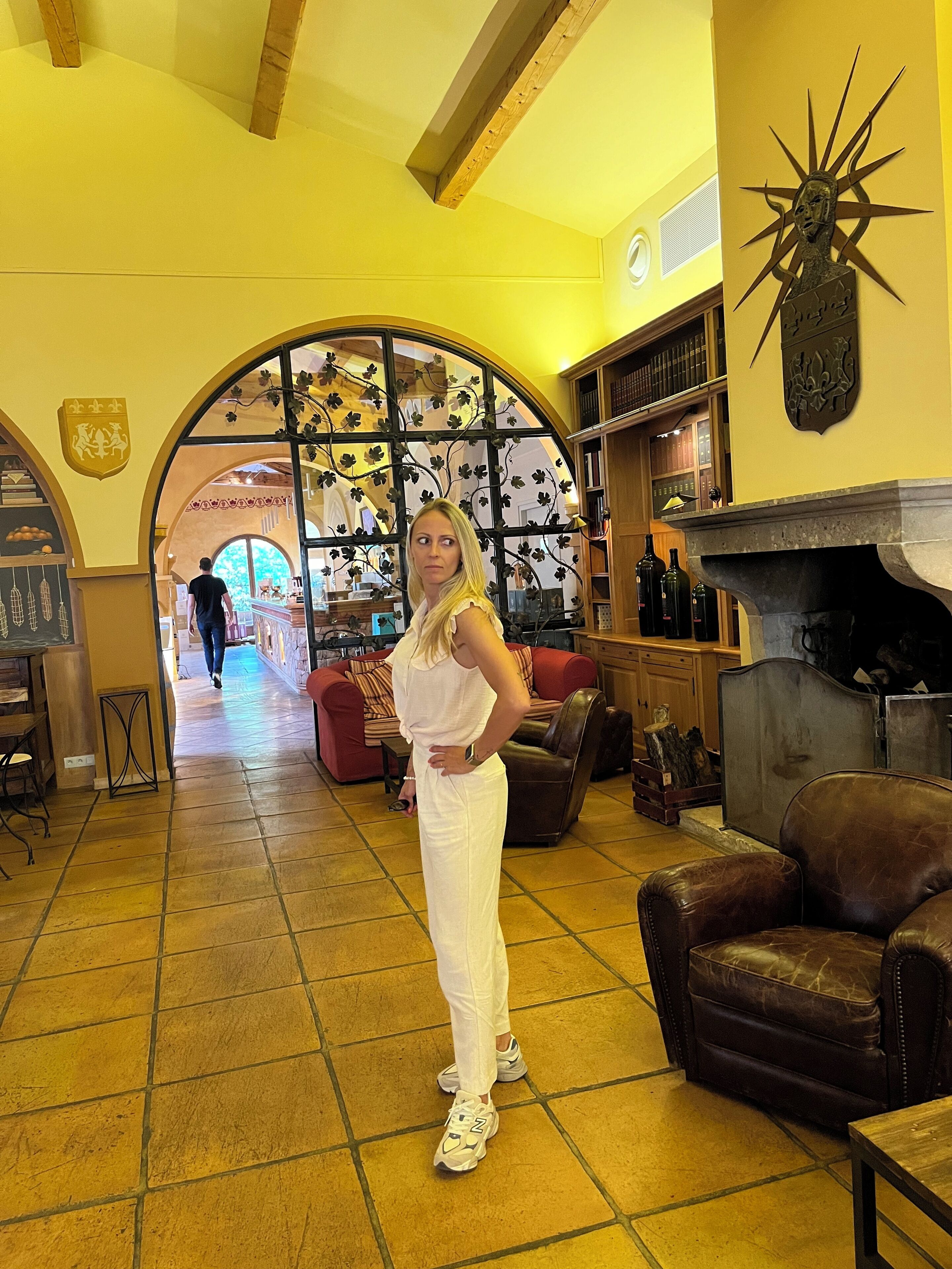 A spacious interior with a high ceiling, a fireplace, and a large arched doorway leading to another room.