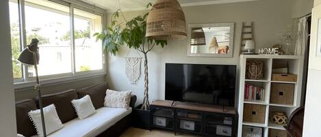 A living room with a sofa, TV, and storage units.