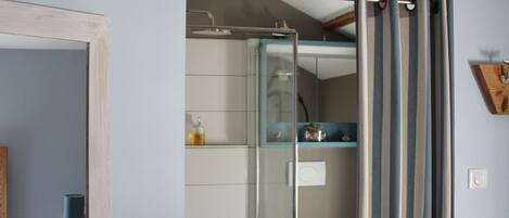 A bathroom with a shower, toilet, and a mirror.