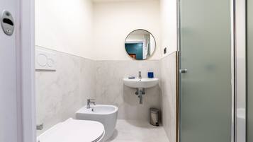 A modern bathroom with a toilet, bidet, and sink.
