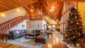 A spacious living room with a wooden ceiling, a staircase, a Christmas tree, and a cozy seating area. - Spacious Cabin w/Hot Tub~2 King beds, fire pit (Slatyfork)
