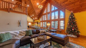 A spacious living room with a large sectional sofa, a wooden coffee table, and a Christmas tree. - Spacious Cabin w/Hot Tub~2 King beds, fire pit (Slatyfork)