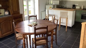 Une cuisine dotée d’un îlot central, de meubles de rangement en bois et d’une table à manger avec des chaises.