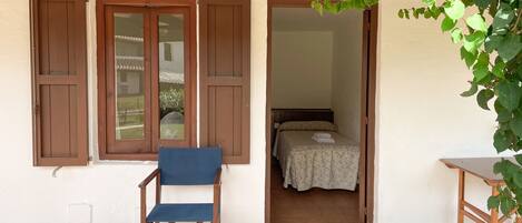 A room with a bed, a chair, and a small table.