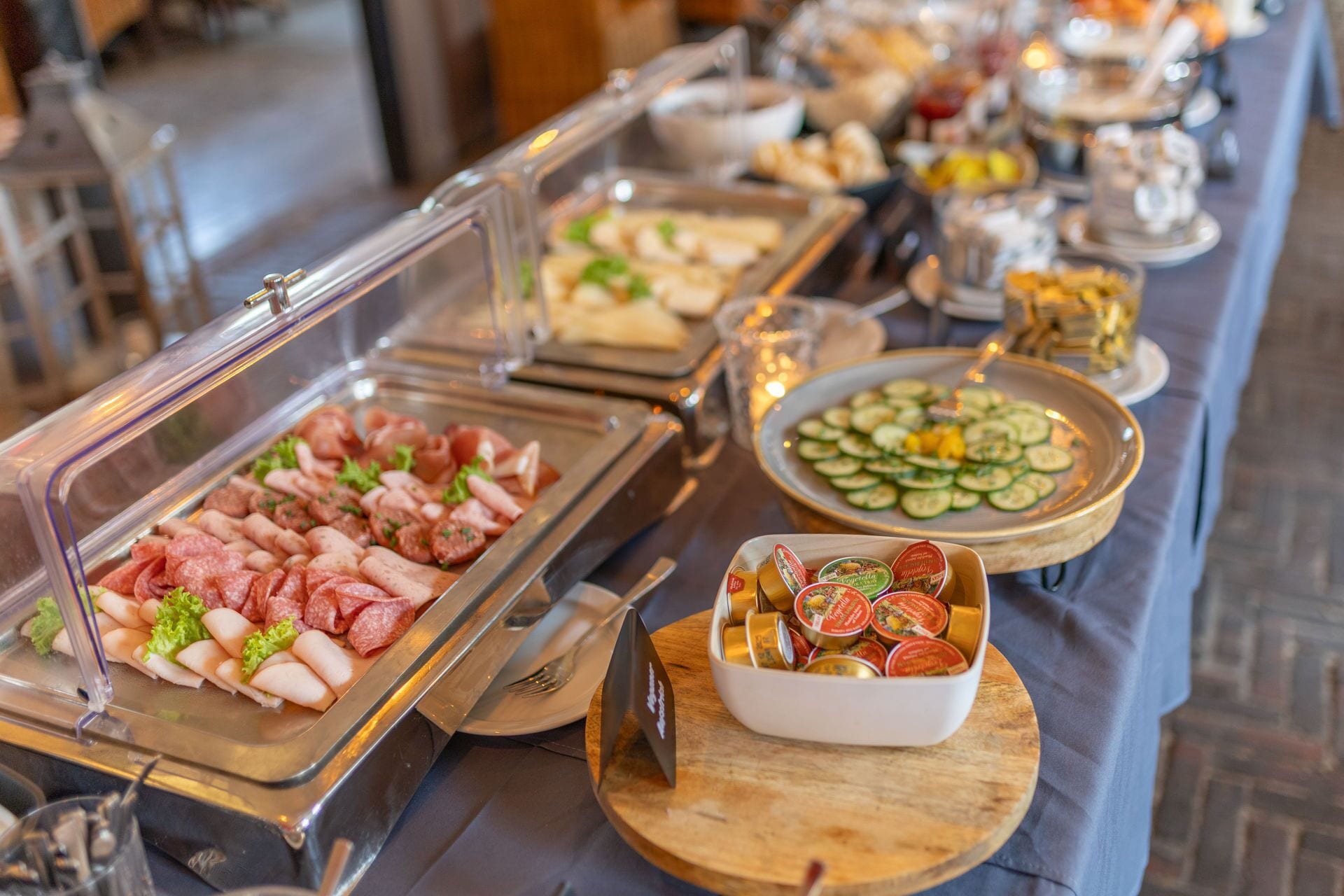 A buffet with various food options including meats, cheeses, and vegetables.
