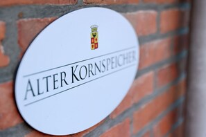 A white sign with the text "ALTER KORNSPIECHER" and a coat of arms.