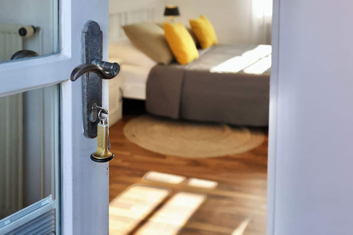 A bedroom with a bed, a window, and a door.