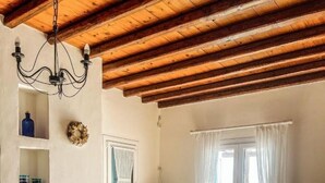 Una sala de estar acogedora con chimenea, un sofá, un televisor y una mesa de comedor.