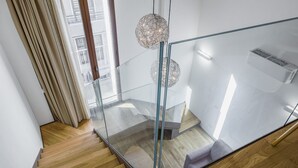 A modern staircase with glass railings, wooden steps, and a view of the outside. - Vecchio Bastione Apts by Wonderful Italy (Catania)