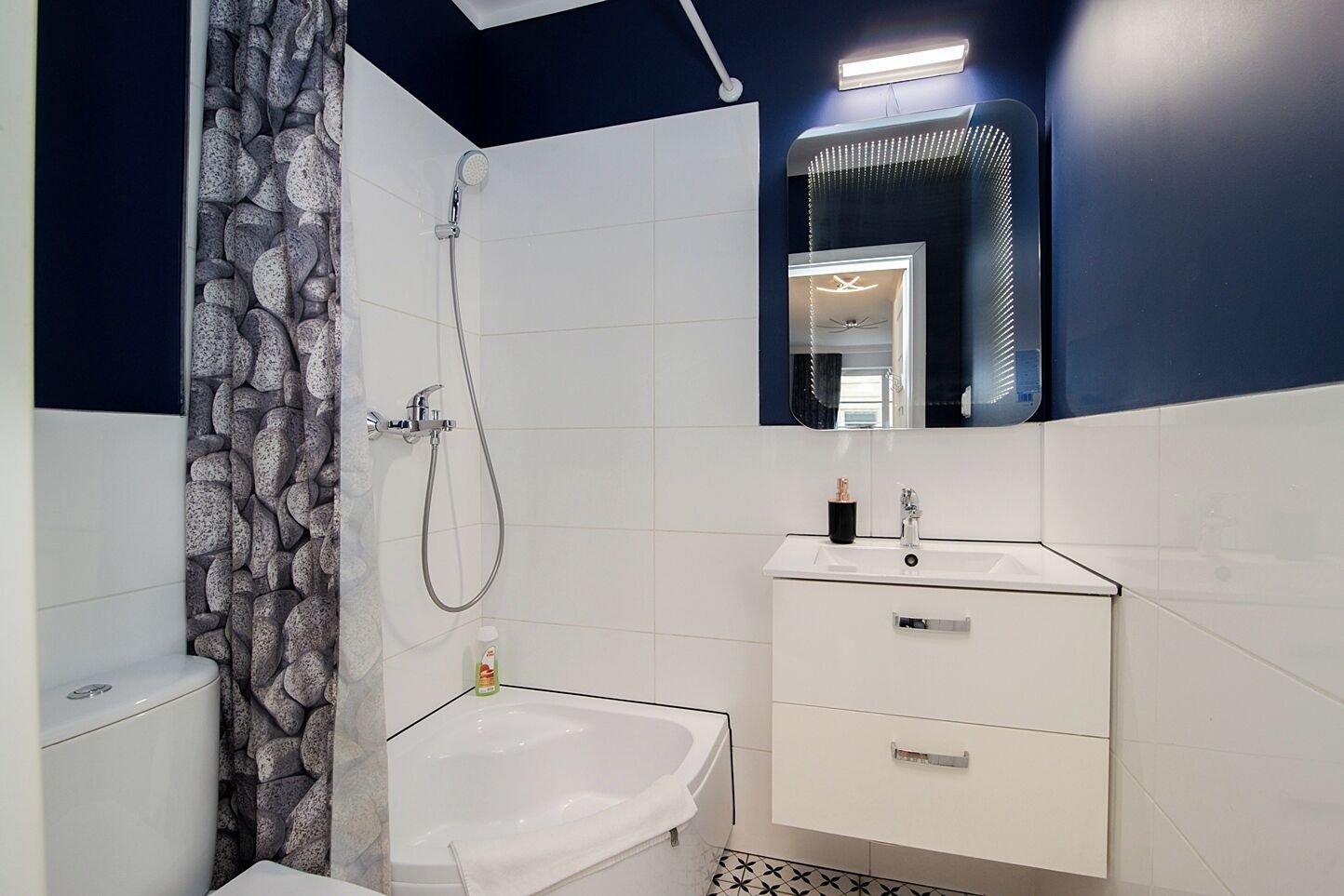 Une salle de bain moderne équipée d’une douche, d’un lavabo et de toilettes.