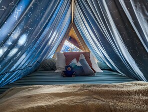 A cozy tent with a bed, pillows, and a stuffed toy. - Spacious Cabin with Hot Tub, Fire Pit, Game Room (Island Park,)