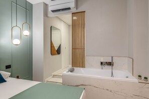 A modern bathroom with a bathtub, a mirror, and a wooden panel divider. - 7heaven pontevecchio rooms (Florence)