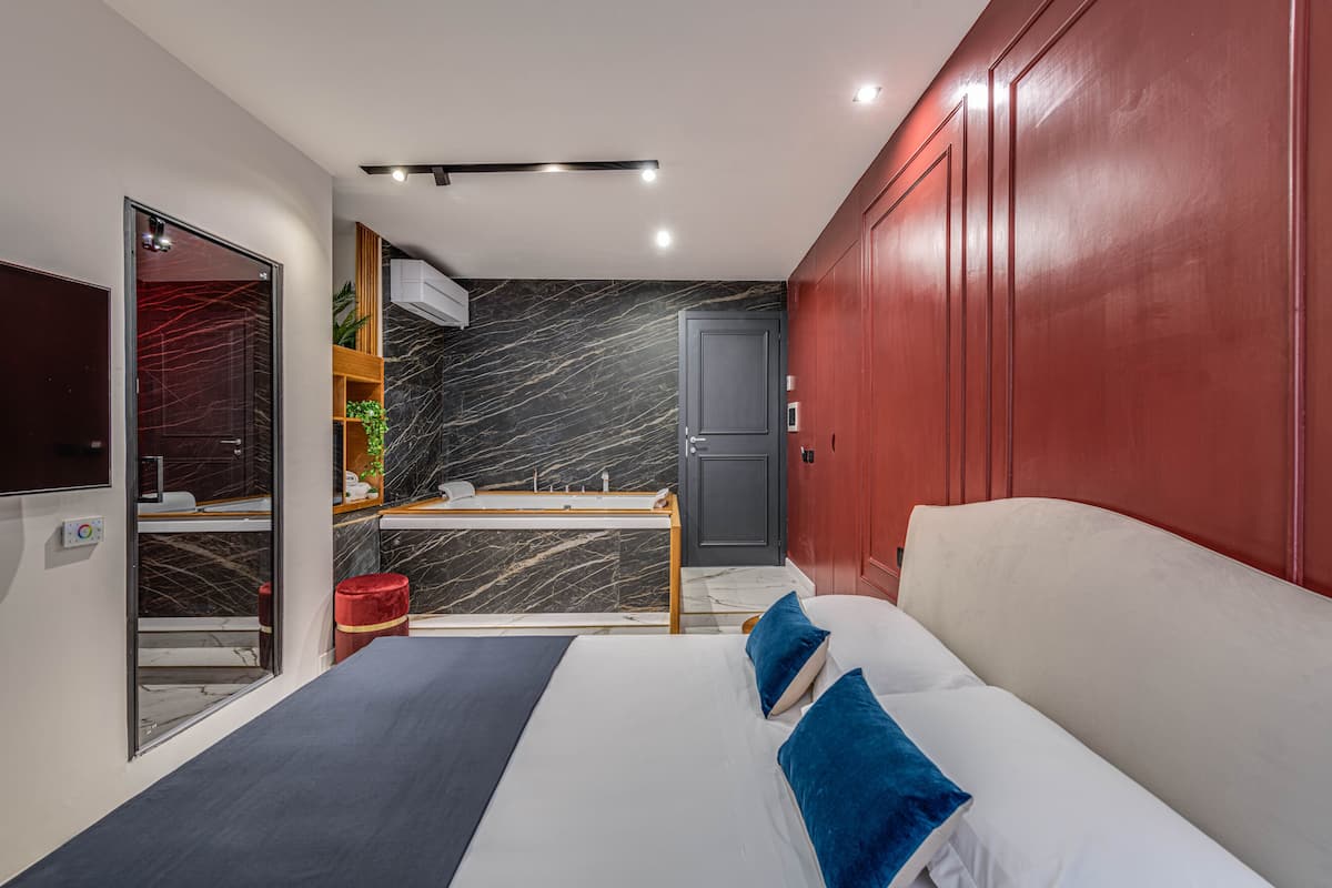 Een moderne hotelkamer met een bed, een bureau, een kledingkast en een badkamer.