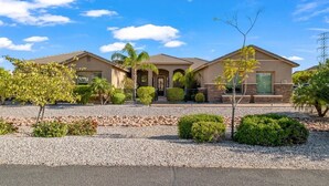 A two-story house with a symmetrical facade, a front entrance with a door, and a small porch area. - Welcome to Paradise | Pool Table, Swim Up Bar, Htd Pool, Hot Tub, Casita! (Mesa)