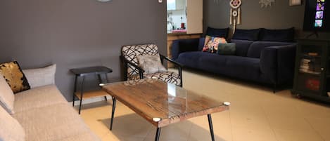 Una sala de estar con un sofá, una mesita de centro y un diván.