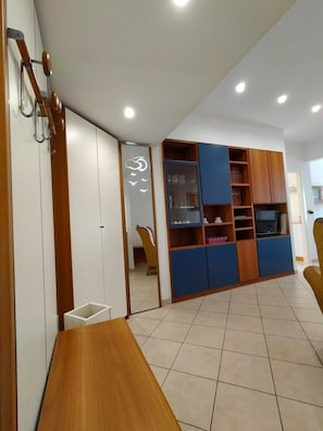 Een moderne woonkamer met een houten tafel, een ingebouwde televisie en een boekenplank.