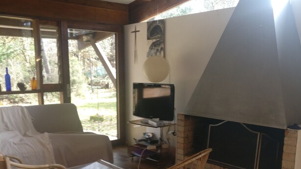 Ein gemütlicher Wohnbereich mit Kamin, Fernseher und Esstisch mit Stühlen.