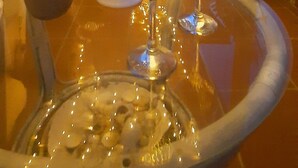 An outdoor patio with a glass table, two wine glasses, and a potted plant. - La Mansarda Suite (Benevento)
