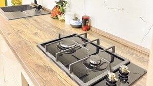 Cozinha com fogão a gás, pia e micro-ondas.