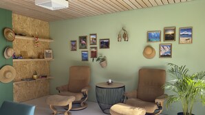 A cozy living room with two armchairs, a small round table, and a potted plant. - BORG Sommerhotell (Ålesund)