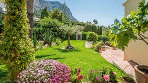 A well-maintained garden with a variety of plants and a clear view of a mountain in the background. - 3 Bedroom Family Villa with Pool (Javea / Xàbia)