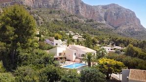 A hillside property with a swimming pool, surrounded by lush greenery and a mountainous backdrop. - 3 Bedroom Family Villa with Pool (Javea / Xàbia)