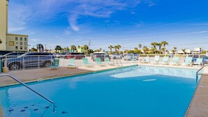 Una piscina con sillas de descanso y una cerca blanca.