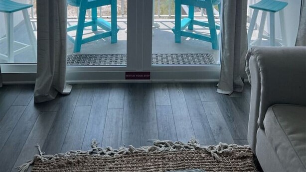 Una habitación con vista al mar a través de una puerta corrediza de vidrio.