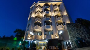 A multi-story hotel with a modern architectural design, featuring balconies and a red carpet entrance. - LİFE POOL SUİTE HOTEL (Trabzon)