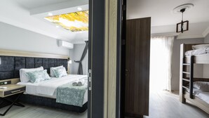 A modern hotel room with a large bed, a desk, and a bunk bed. - LİFE POOL SUİTE HOTEL (Trabzon)