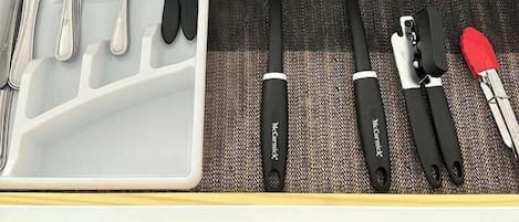 A kitchen drawer with utensils and cookware.