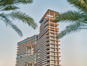 A high-rise building with multiple balconies and a modern architectural design.