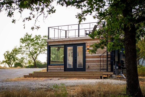 Eine moderne Holzhütte mit großen Fenstern und einem Balkon.