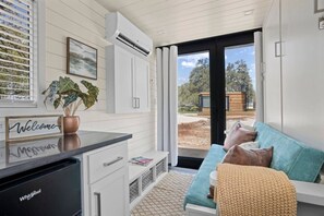 A modern kitchen with a countertop, a dishwasher, and a window with blinds.