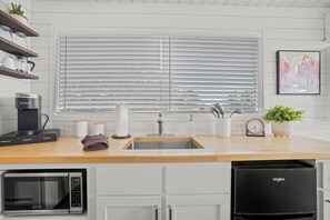 Eine moderne Küche mit integriertem Geschirrspüler, einer Kaffeemaschine und einer Mikrowelle.