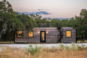 Uma cabana com varanda, escadas e porta.