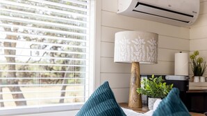 A room with a window, a lamp, a plant, and a bed. - Container home | Roof Patio | Countryside Views (Fredericksburg)