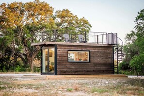 Eine kleine Holzhütte mit Glastür und Fenster.