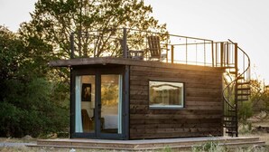 A small cabin with a glass door, a window, and a spiral staircase. - New! The Perry-Chic container home Oasis (Fredericksburg)