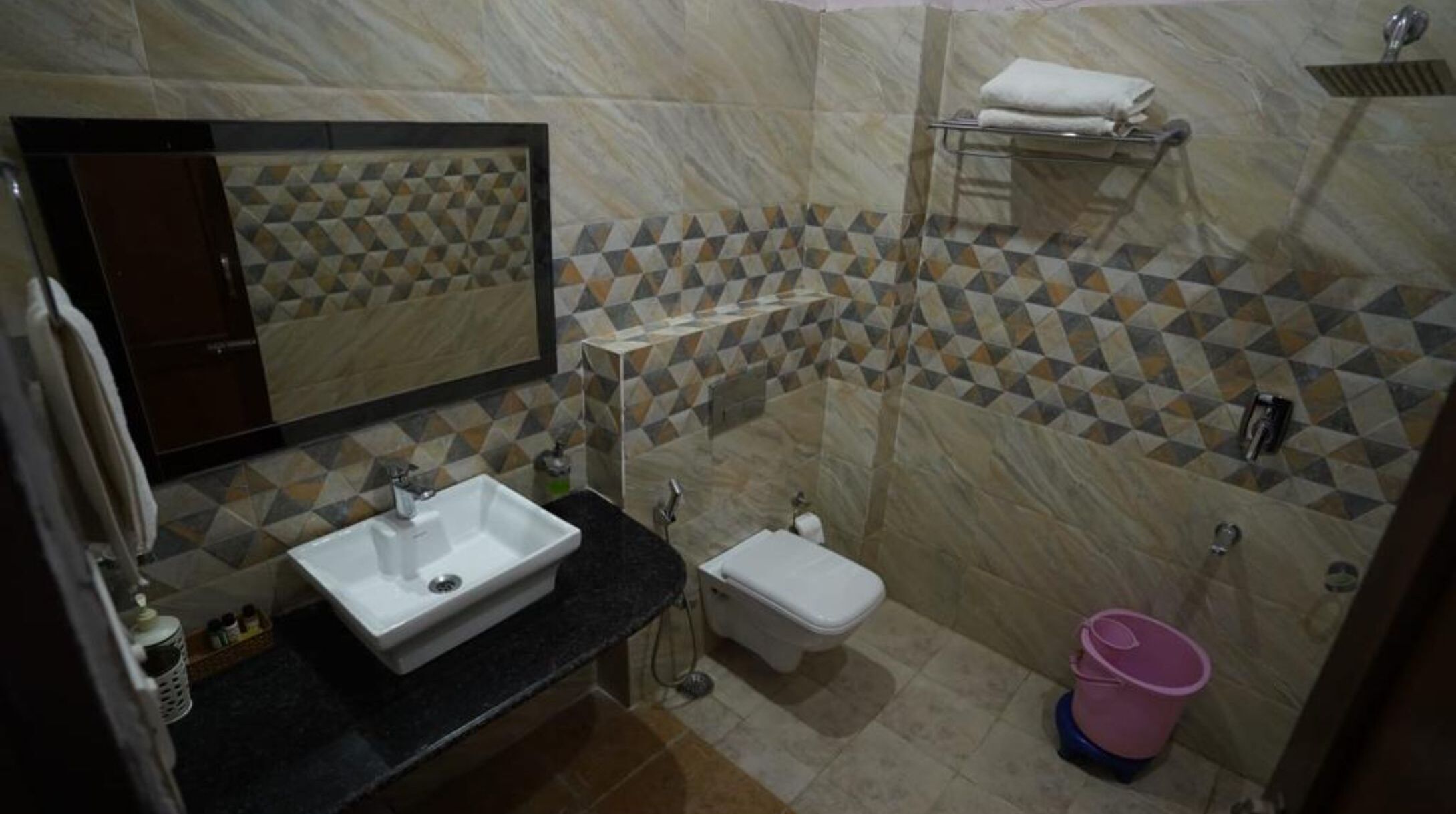 Un baño con lavamanos, inodoro y zona de ducha.