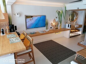 Un soggiorno moderno con una televisione a schermo piatto, mobili in legno e oggetti decorativi.