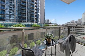 A balcony with a table, chairs, and a potted plant. - A Large 2BR Apt Near Crown, Sleeps 8, FREE Parking (Southbank)