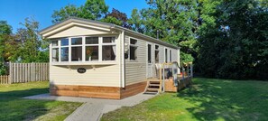 A mobile home with a porch, a small deck, and a front entrance. - Mobile home "Uns Fischernüst 2" - your cozy retreat in East Frisia (Hinte)