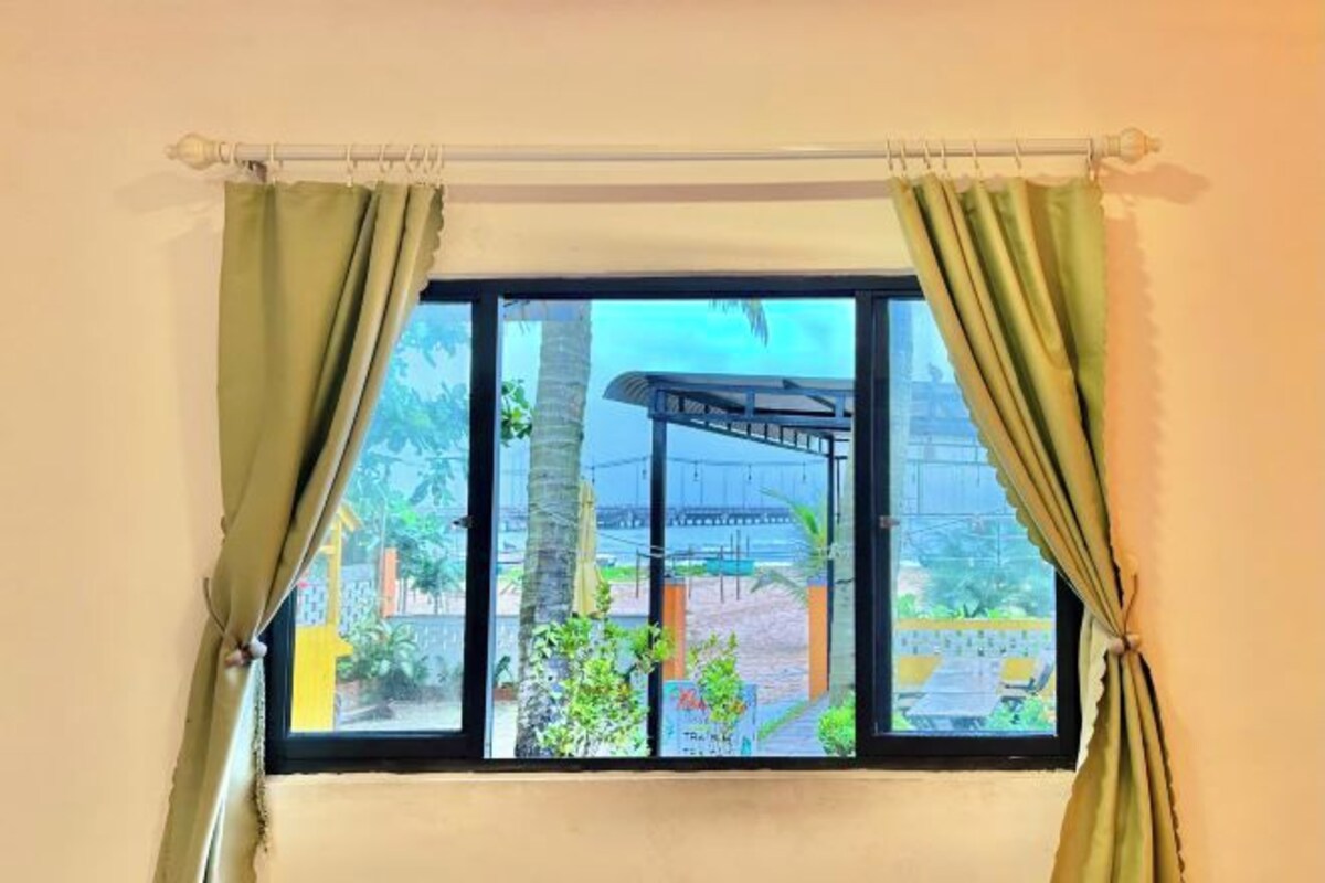 A window with a view of a bridge and greenery outside.