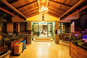 A hotel lobby with a wooden ceiling, a reception desk, and a seating area with chairs and tables. - Kutberk otel (Kemer)